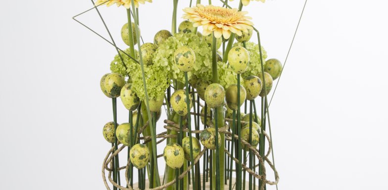 Bloemwerk met zachtgele gerbera's en sneeuwbal voor de Pasen