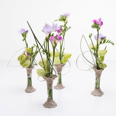 Vaasjes met klei en paarse Freesia's