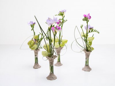 Vaasjes met klei en paarse Freesia's